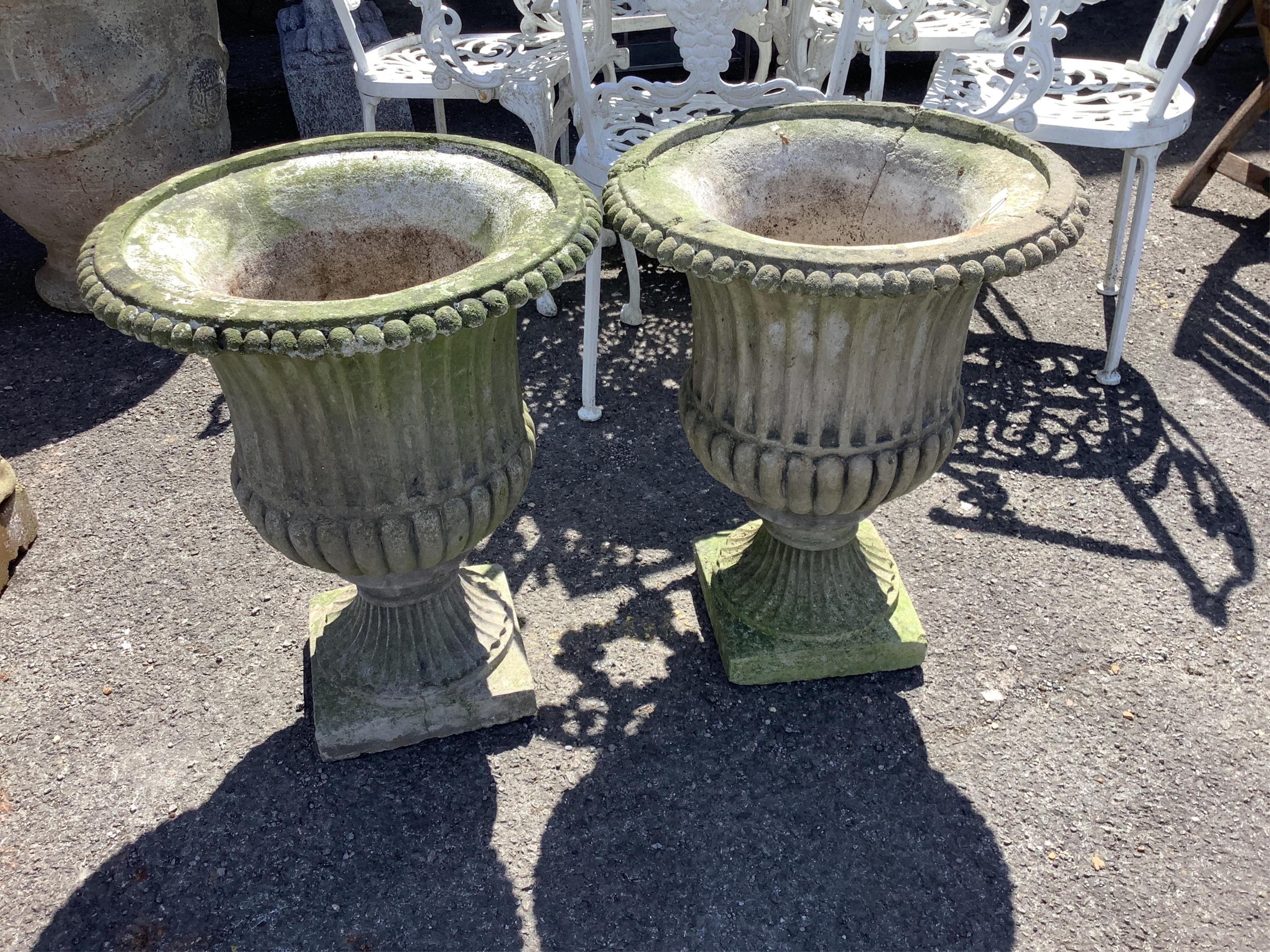 A pair of reconstituted stone campana garden urns on pedestal bases, diameter 46cm, height 58cm